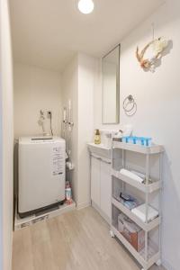 a bathroom with a sink and a white refrigerator at night-night 東京ドーム便利 江戸川橋駅近 池袋銀座直通 商店街徒歩圏内 in Tokyo