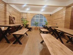 an empty room with wooden tables and potted plants at Ratnagiri Boutique Hotel in Mirik