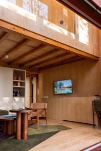 a living room with a table and a tv on a wall at Torre de Gomariz Wine & Spa Hotel in Braga