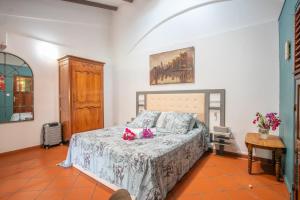 a bedroom with a bed and a table at Alpinia-Martinique, à 5 minutes de la plage in Sainte-Anne