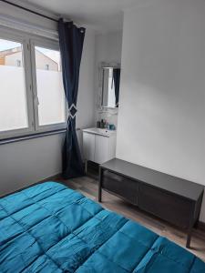 a bedroom with a blue bed and a window at Appart 1 bray dunes Minouche in Bray-Dunes +6 photos