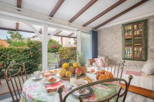 a table with a plate of fruit on a porch at Alpinia-Martinique, à 5 minutes de la plage in Sainte-Anne