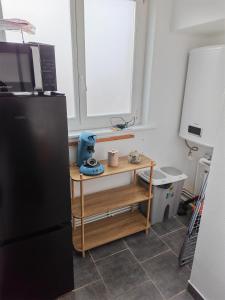 a kitchen with a black refrigerator and a table at Appart 1 bray dunes Minouche in Bray-Dunes