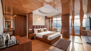 a bedroom with a bed in a room with windows at Yashshree Jai Hotel & Banquet in Darjeeling +69 photos