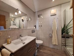 a bathroom with a sink and a toilet and a mirror at Gästehaus Annabell in Nesselwang +69 photos