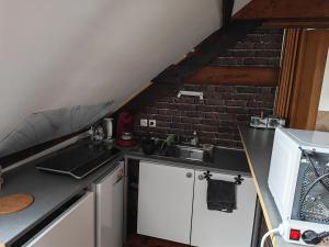 a kitchen with a sink and a brick wall at Appart 3 sous combles in Bray-Dunes +1 photo