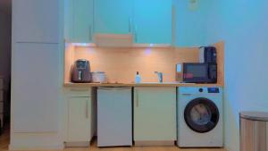 a kitchen with a washing machine and a microwave at Bright and cozy studio entre Paris et Disneyland in Champs-sur-Marne