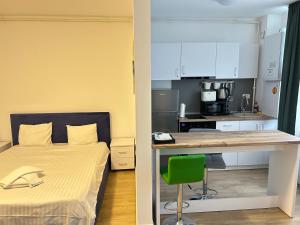 a bedroom with a bed and a desk and a kitchen at Studio Pompeiu in Bucharest +13 photos