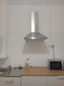 a kitchen with a sink and a microwave at hôtel des reformés in Marseille +6 photos