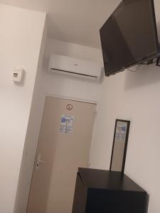 a room with a flat screen tv and a door at hôtel des reformés in Marseille