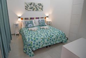 a bedroom with a bed with a blue bedspread at B&B RoseMary in La Maddalena
