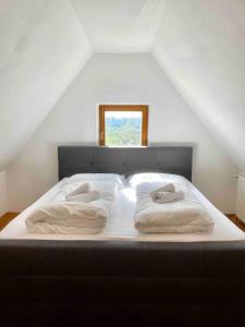 a bed with two pillows on it in a attic at Gemütliche Landhauswohnung in Bad Saulgau