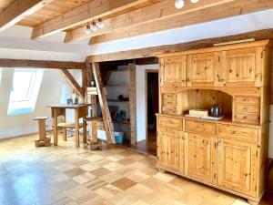 a kitchen with wooden cabinets and a table at Gemütliche Landhauswohnung in Bad Saulgau