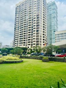 a large building with a green lawn in front of it at The Crescat Suite by Cinnamon Grand in Colombo