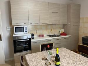a kitchen with a table with a bottle of wine at La Terasa del Cichino in Roe
