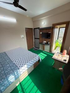 a bedroom with a bed and green carpet at Palashbhumi Resort in Barhanti