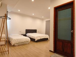 a room with two beds and a door and a ladder at Pasadena Home in Tawau