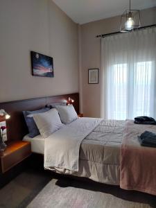 a bedroom with a large bed and a window at GRAND HOUSE METEORA in Kalabaka
