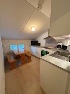 a kitchen with a wooden table and a counter top at Korpinpesä in Korppoo