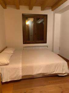 a bed in a room with a cabinet on the wall at Casina sulle dolomiti in Borca di Cadore