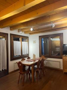 a dining room with a wooden table and chairs at Casina sulle dolomiti in Borca di Cadore