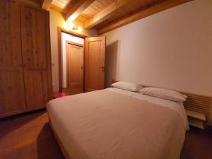 a bedroom with a large white bed with two pillows at Casina sulle dolomiti in Borca di Cadore