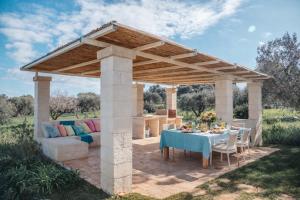 a pergola with a table and a couch at Dimora Stune in Ostuni