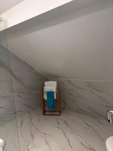 a bathroom with white marble walls and a mirror at Studio Léo in Bôle +4 photos