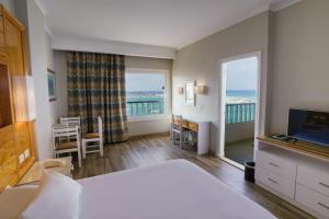 a bedroom with a bed and a view of the ocean at Beau Site Hotel in Marsa Matruh