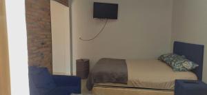 a bedroom with a bed and a tv on the wall at Casa M&T in Encarnación