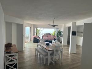 a dining room and living room with a table and chairs at The Windsock in Ballito