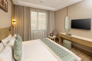 a hotel room with a bed and a desk and a television at فندق عفراء in Mecca