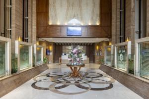 a lobby with a fountain with flowers in it at فندق عفراء in Mecca