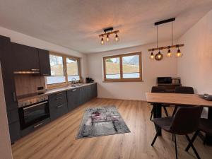 a kitchen and living room with a table and a dining room at Ferienwohnungen Moser in Steinberg am Rofan