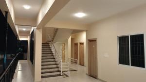 a hallway of a house with stairs and a window at Sansav Garden Resort in Gurpur