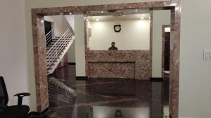 a man standing in front of a mirror in a room at Sansav Garden Resort in Gurpur