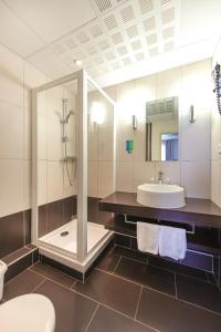 a bathroom with a shower and a sink and a toilet at Hôtel Vacances Bleues Balmoral in Menton