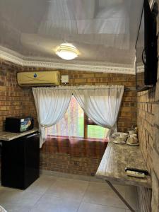 a kitchen with a table and a window with curtains at 14 Mirage crescent in Welkom