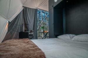a bedroom with a bed and a large window at The Glass Globe in Traphill