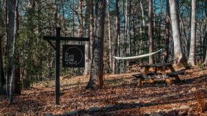 a sign and a picnic table in the woods at The Glass Globe in Traphill