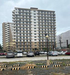 a large building with cars parked in a parking lot at Skyline Studio Marigondon in Marigondon