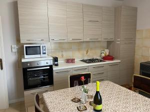 a kitchen with a table with a bottle of wine at La Terasa del Cichino in Roe +9 photos