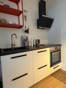 a kitchen with a sink and a stove at Quendel & Äpfel Ferienhaus in Neu Wulmstorf +13 photos
