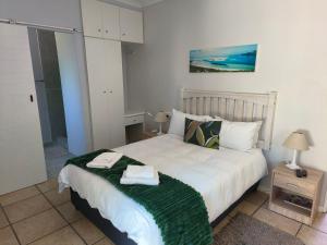 a bedroom with a bed with two towels on it at Croeso Guest House in Langebaan