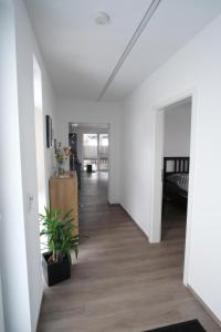 a hallway with white walls and wood floors and a room at Ferienwohnung Lerchenstraße in Schwerin