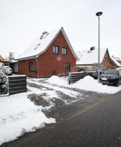 a house with snow on the ground next to a street at Ferienwohnung Lerchenstraße in Schwerin