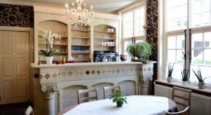 a dining room with two tables and a kitchen at B&B l'Heritage in Lo-Reninge