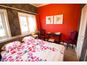a bedroom with red walls and a bed and two chairs at B&B l'Heritage in Lo-Reninge