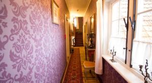 a hallway with a purple wall with a window at B&B l'Heritage in Lo-Reninge