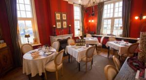 a restaurant with tables and chairs in a room with red walls at B&B l'Heritage in Lo-Reninge